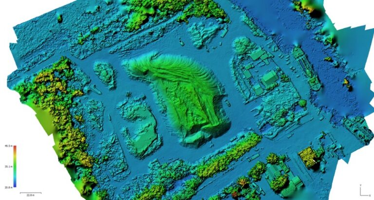 Mapa topográfico en color que muestra los datos de elevación de un yacimiento arqueológico con estructuras y características del terreno; las elevaciones más altas aparecen en verde y amarillo, las más bajas en azul. La barra de escala y la brújula son visibles.